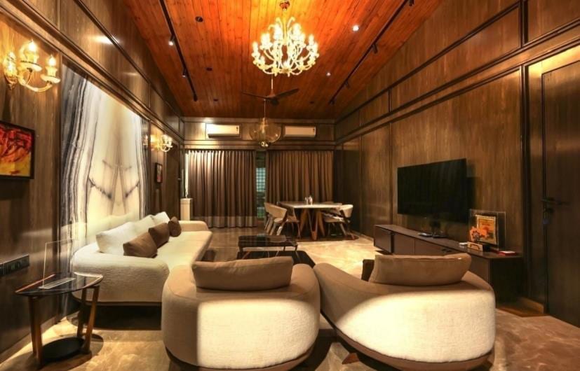 Cosy seating nook with round tub chairs, wood panelling and a chandelier.