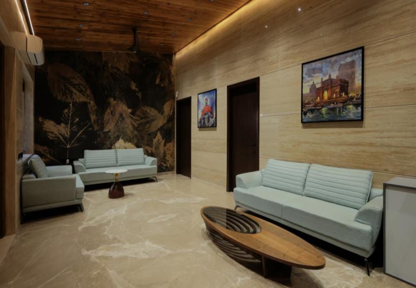 Living area with a sofa set against a warm wood-panelled wall.