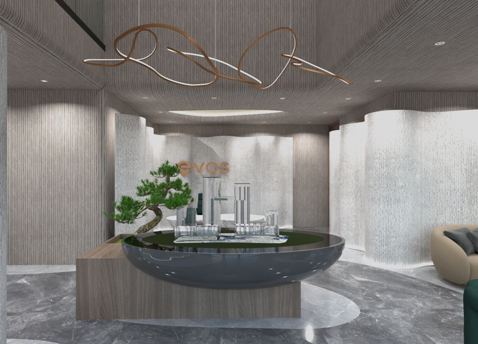 Open lounge with green accent chairs and curved sofas around the model-display feature, sculptural pendants overhead and garden views beyond.